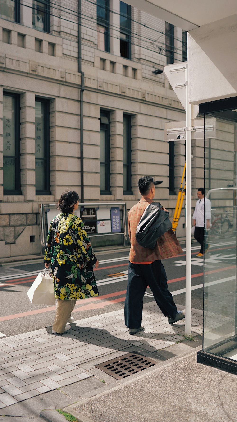 homme en veste à fleurs noire et jaune debout à côté d’une femme en robe à fleurs noire et blanche