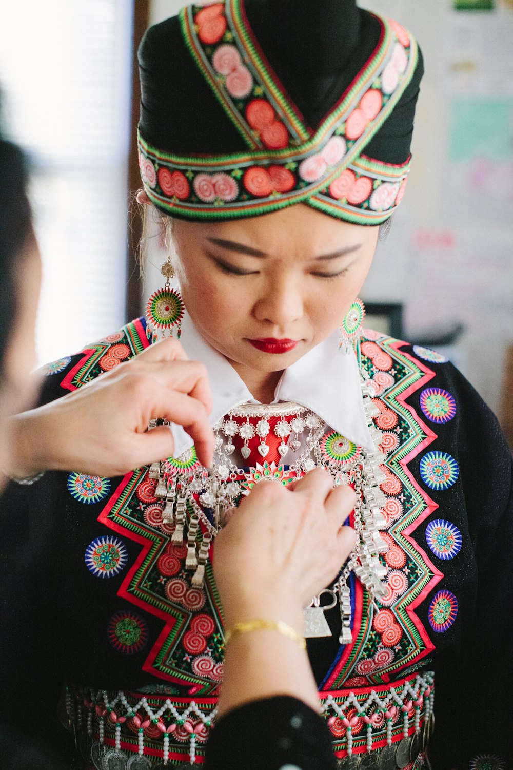 woman in black and red floral dress wearing green and yellow headdress