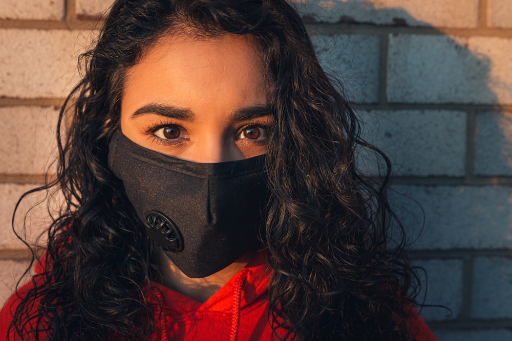 woman in red shirt wearing black mask