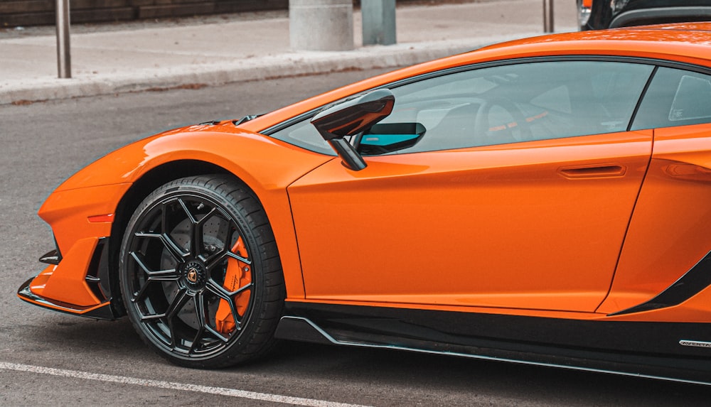 an orange sports car parked in a parking lot