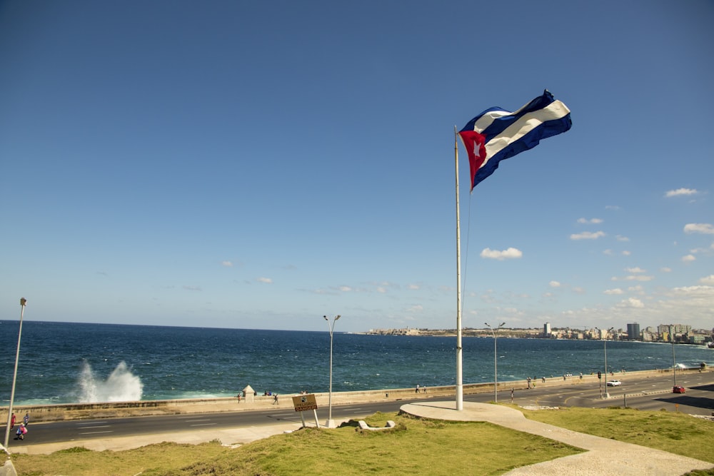 Bandera de nosotros A en el mástil junto al mar durante el día