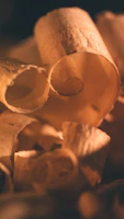 Macro shot revealing the fine grain detail and warm tones of walnut veneer under soft industrial lighting.