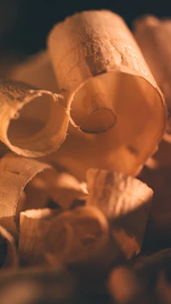 Close-up of premium wood pieces laid out for expert selection in a warm, elegant workshop setting.