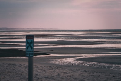 A vertical card showing a peaceful beach sunset in Kerala with gentle waves and a soft overlay inviting exploration.