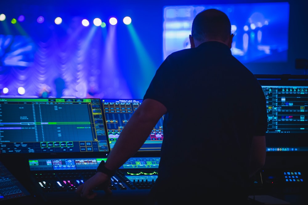 homem na camiseta preta que joga o mixer de áudio