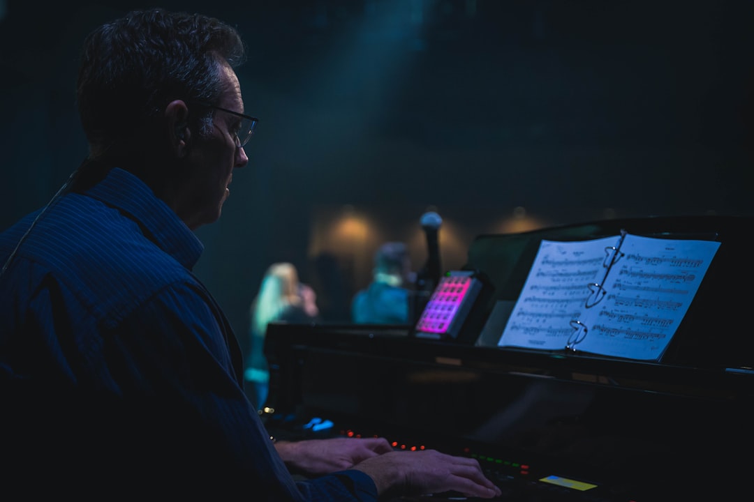  man in blue dress shirt wearing black framed eyeglasses record player