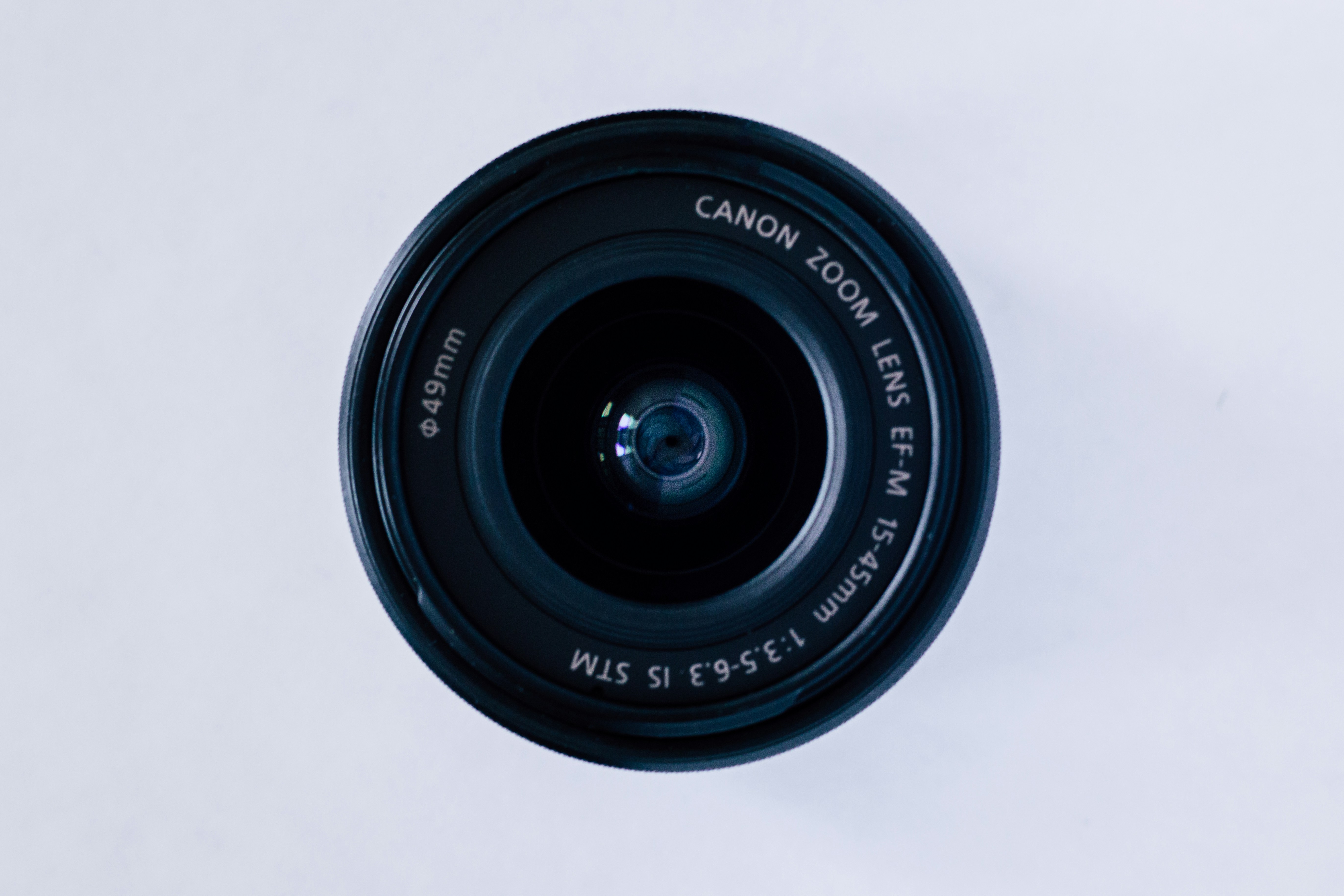 black canon camera lens on white surface
