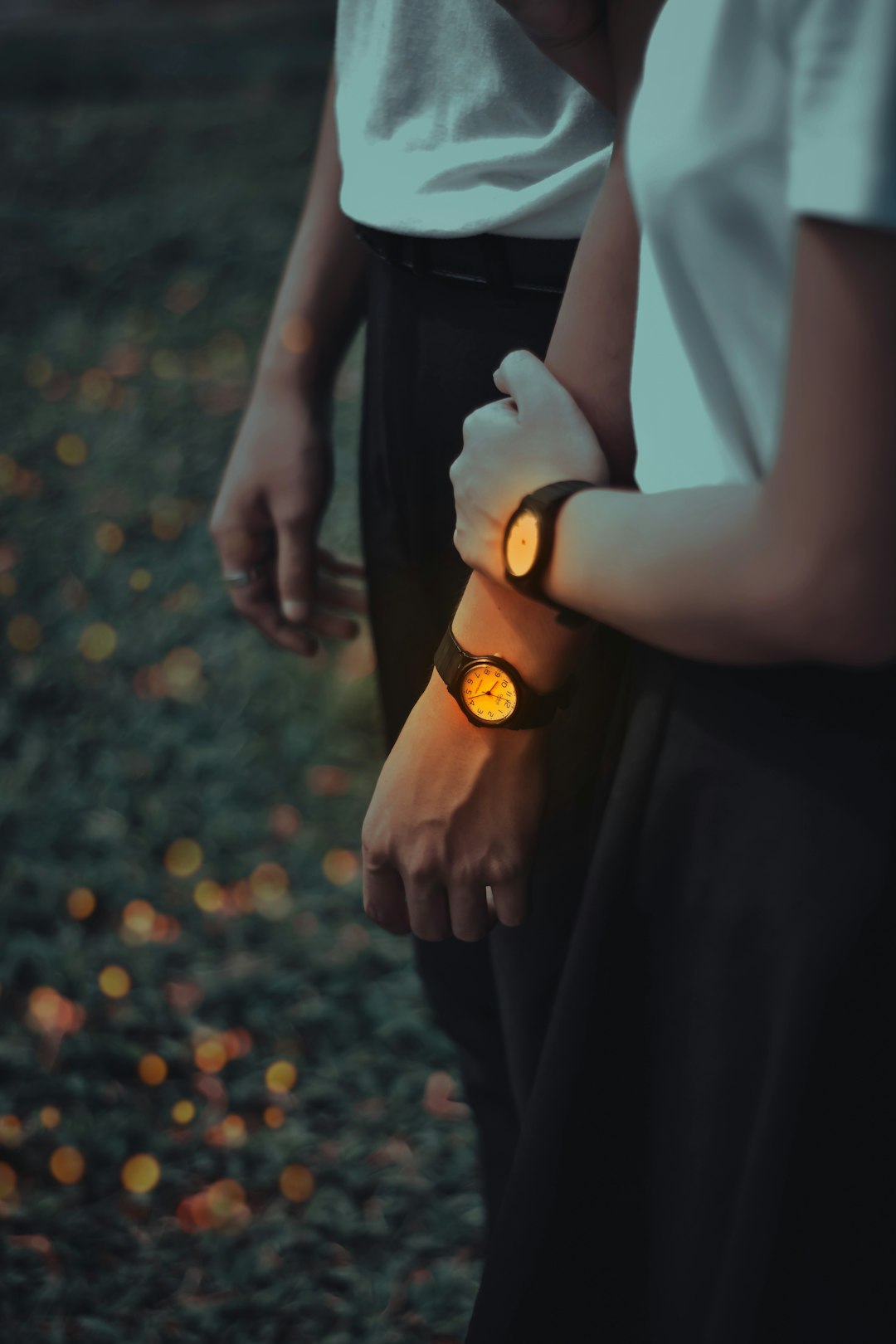 woman in black dress holding hands with man in white shirt