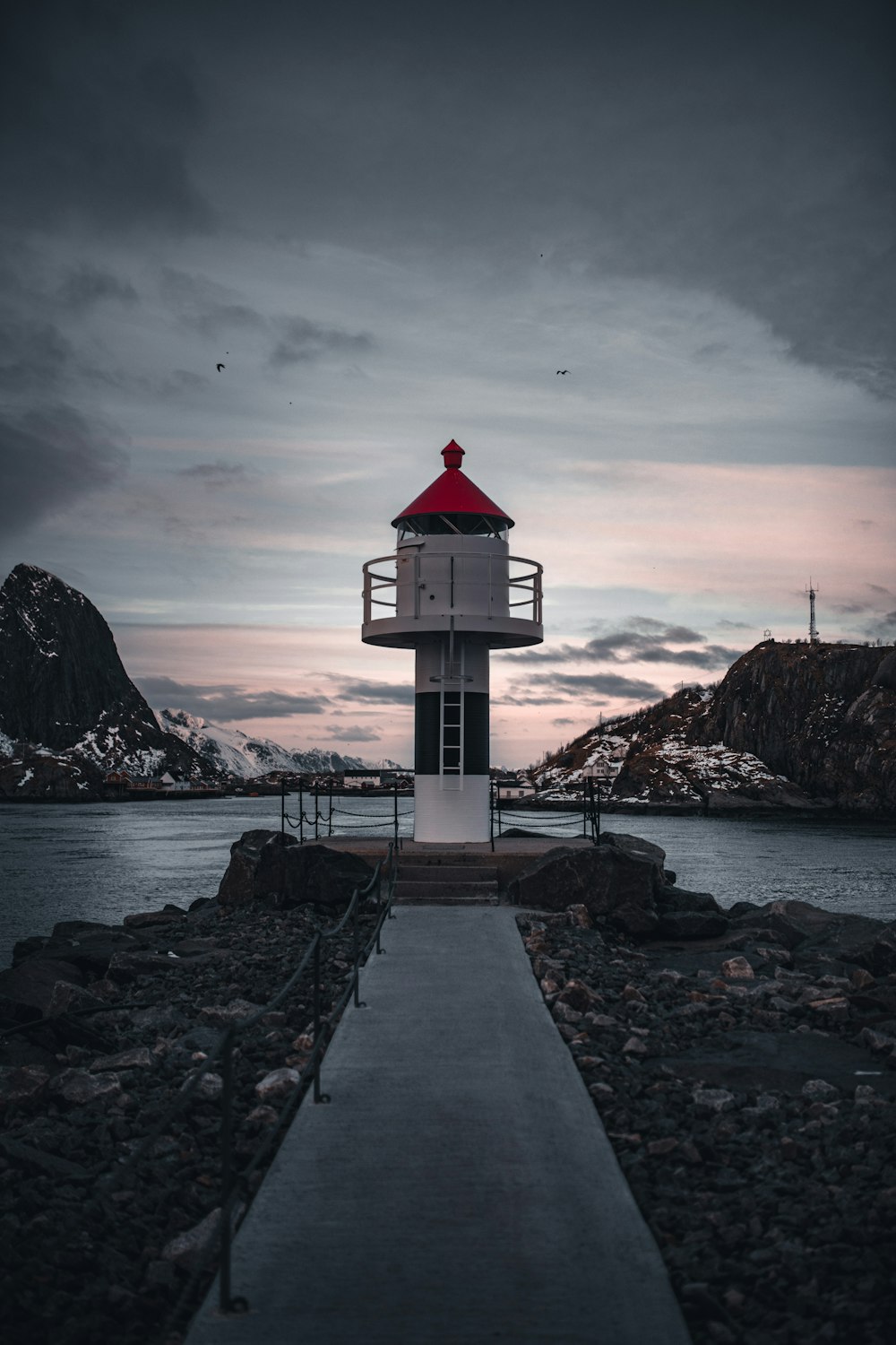 white and red lighthouse near body of water during daytime