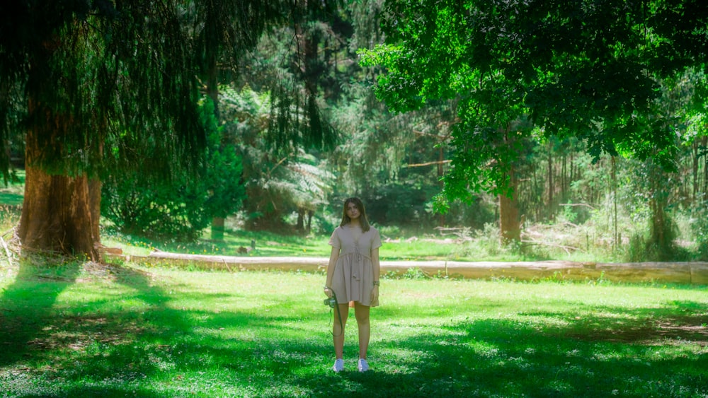 woman in brown dress standing on green grass field during daytime