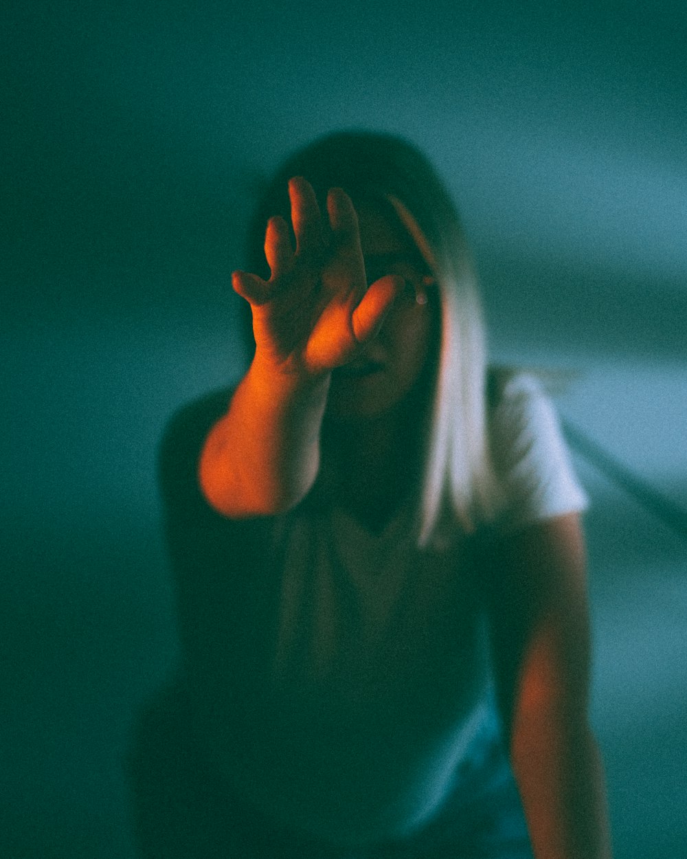 woman in white t-shirt covering her face