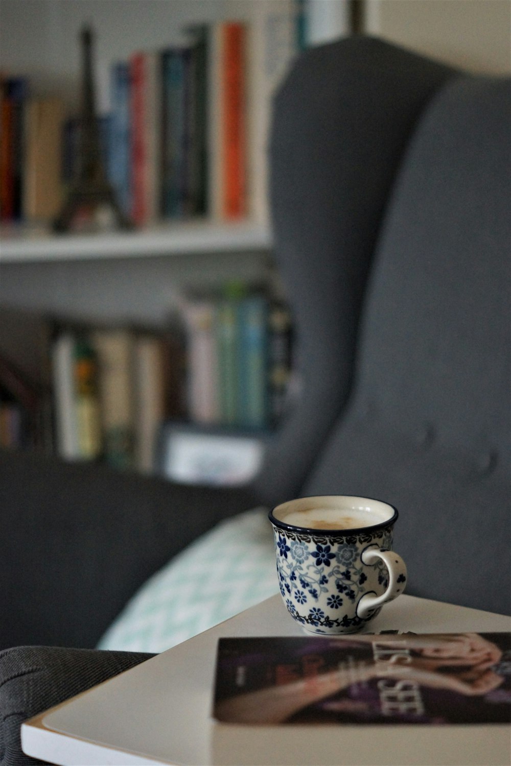 white and blue floral ceramic mug on table