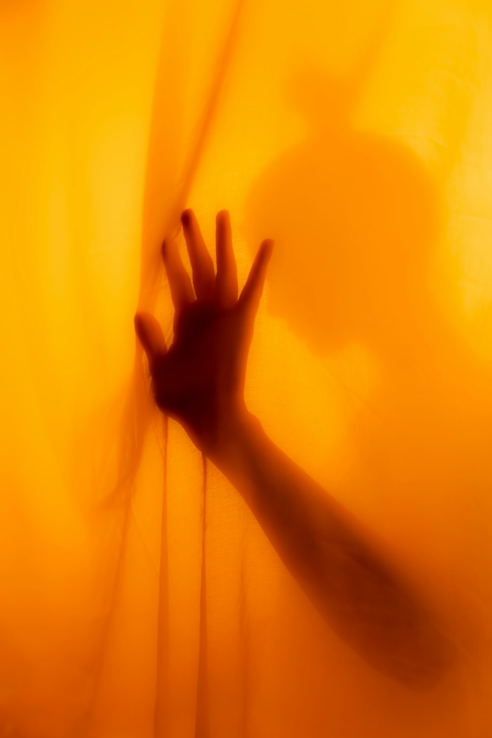 persons hand on yellow textile