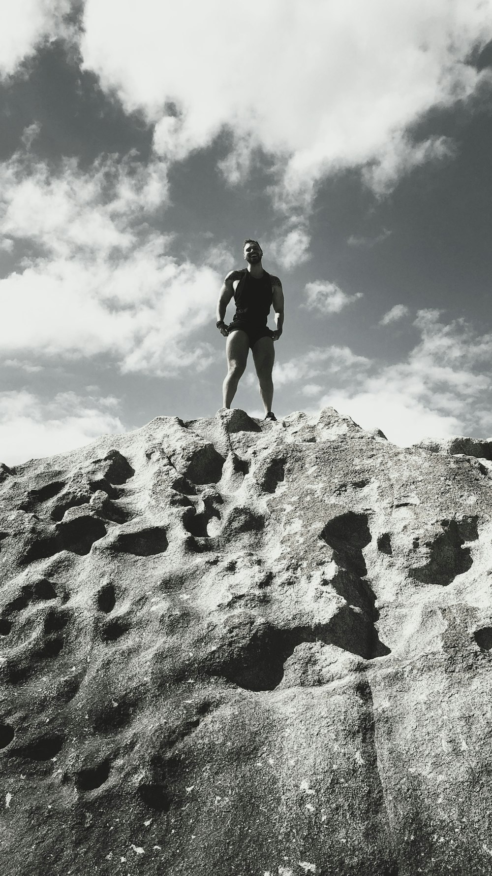 man in black shorts climbing on brown rock during daytime