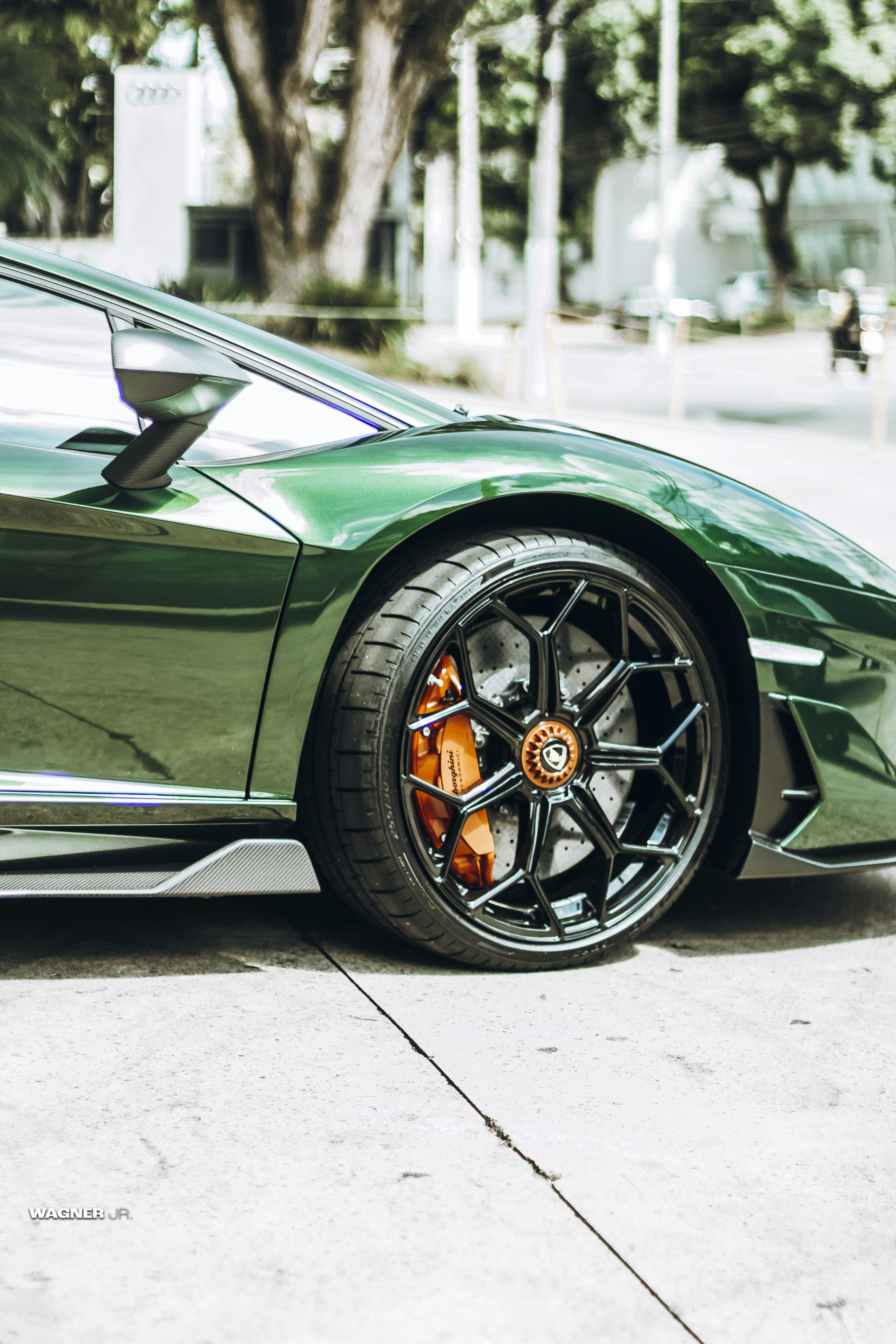 green car on gray asphalt road during daytime