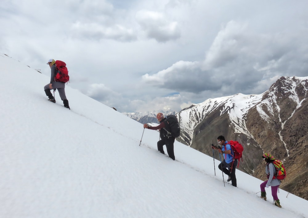 people hiking on snow covered mountain during daytime