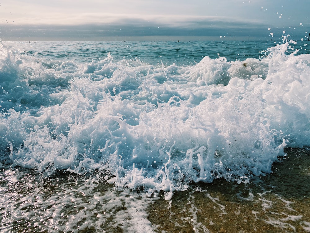 ocean waves crashing on shore during daytime