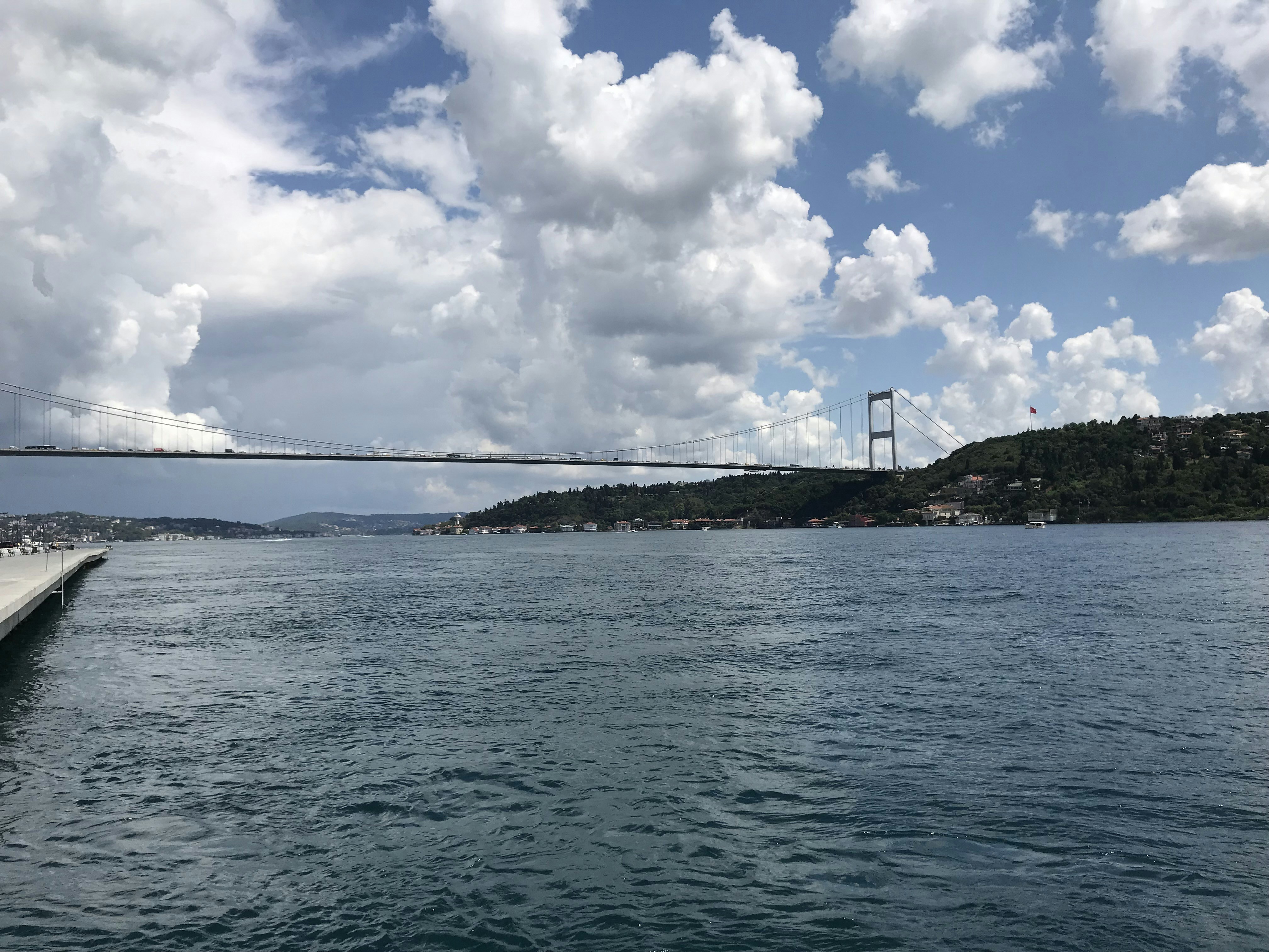 bridge over the sea under white clouds and blue sky during daytime, A bridge connecting 2 continents in Istanbul, Turkey.