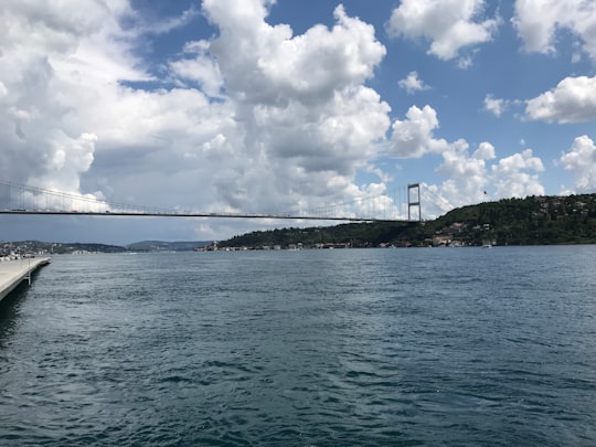 bridge over the sea under white clouds and blue sky during daytime in Rumeli Hisarı Turkey