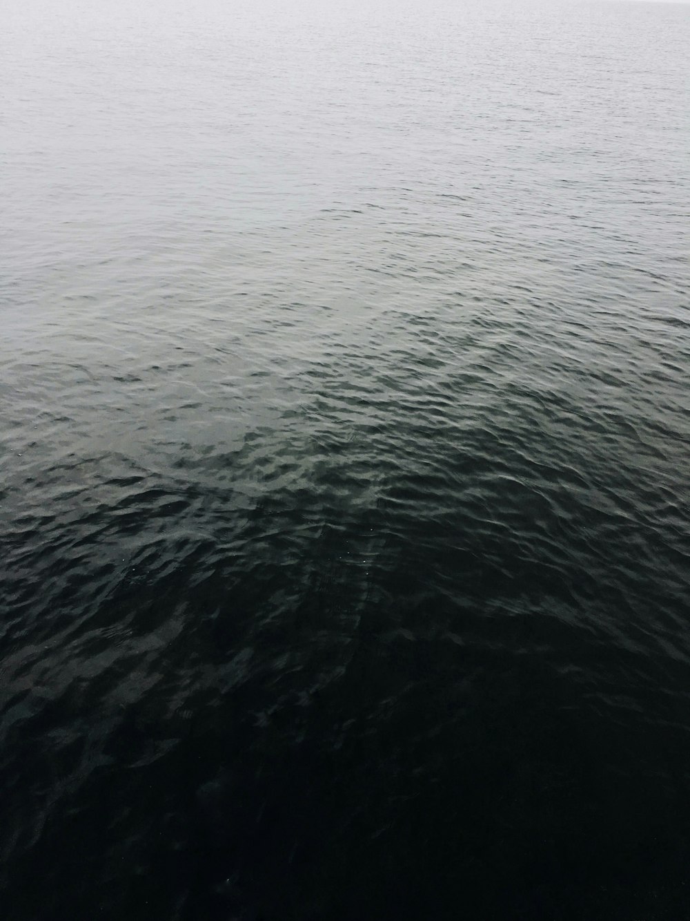 a large body of water with a boat in the distance