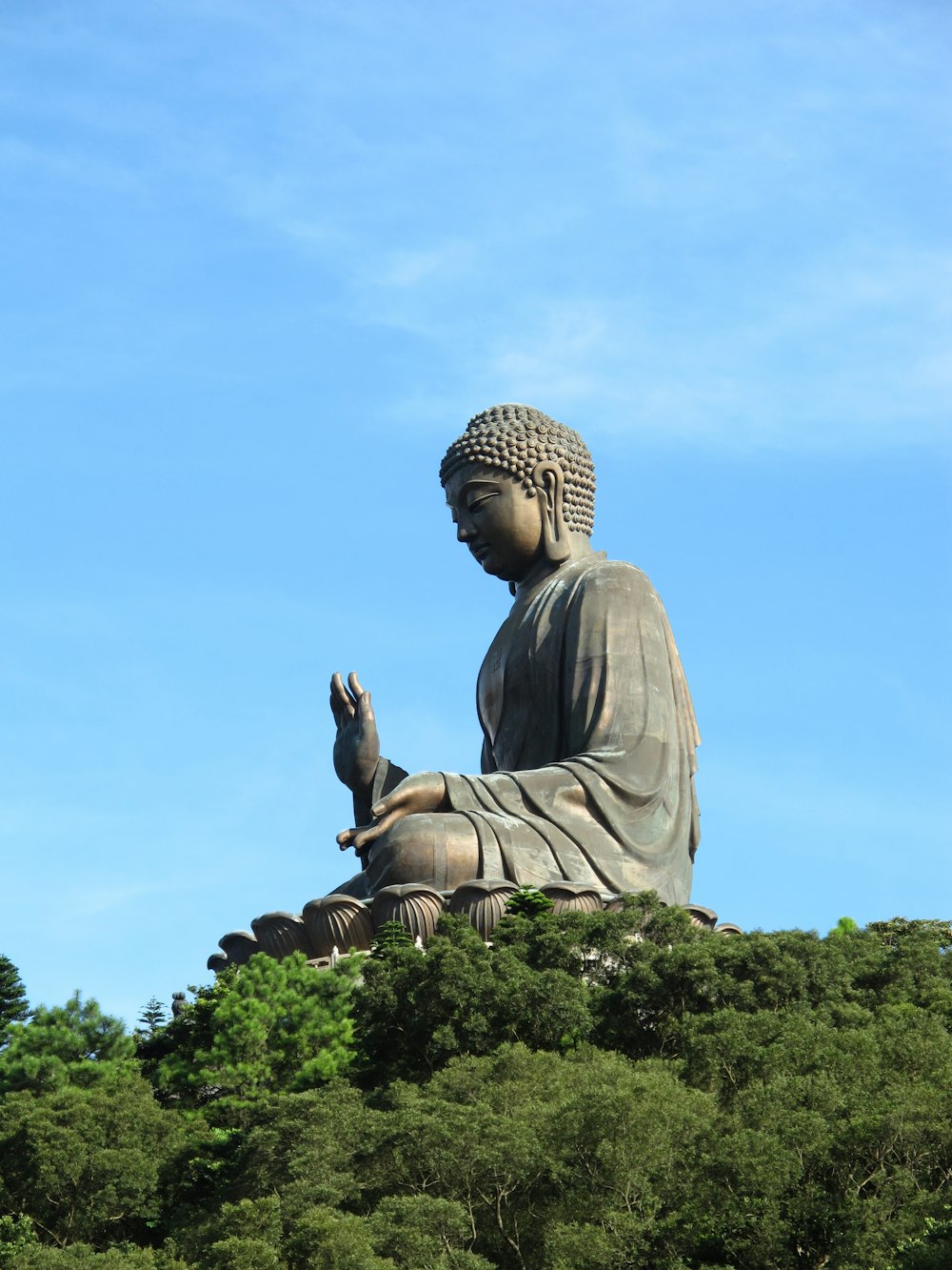 statue of man sitting on rock