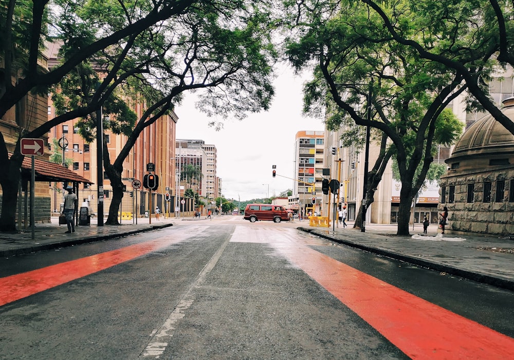 red car on road near trees during daytime