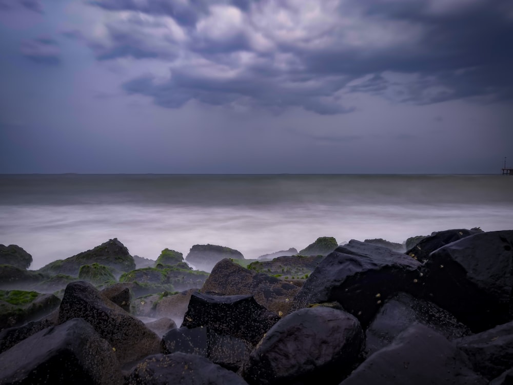 rocky shore under cloudy sky during daytime