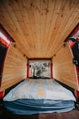 A cozy interior shot of the van showing the handmade woodwork and colorful textiles inside.