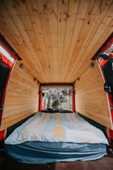 Cozy campervan interior with modular wooden furniture and soft lighting.