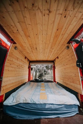 A cozy interior shot of the van showing the handmade woodwork and colorful textiles inside.
