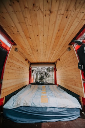 Cozy campervan interior with modular wooden furniture and soft lighting.