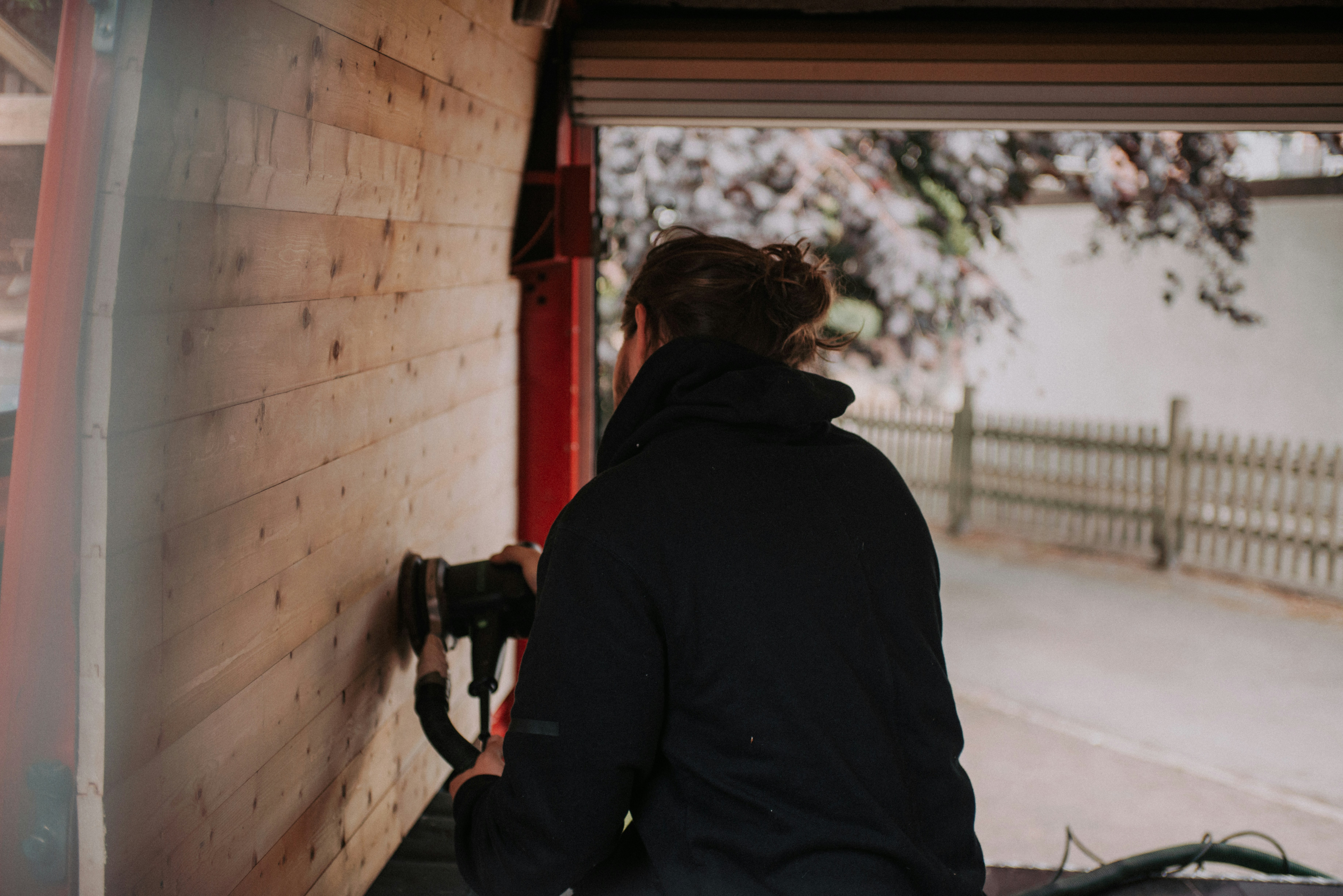 woman in black hoodie holding black dslr camera