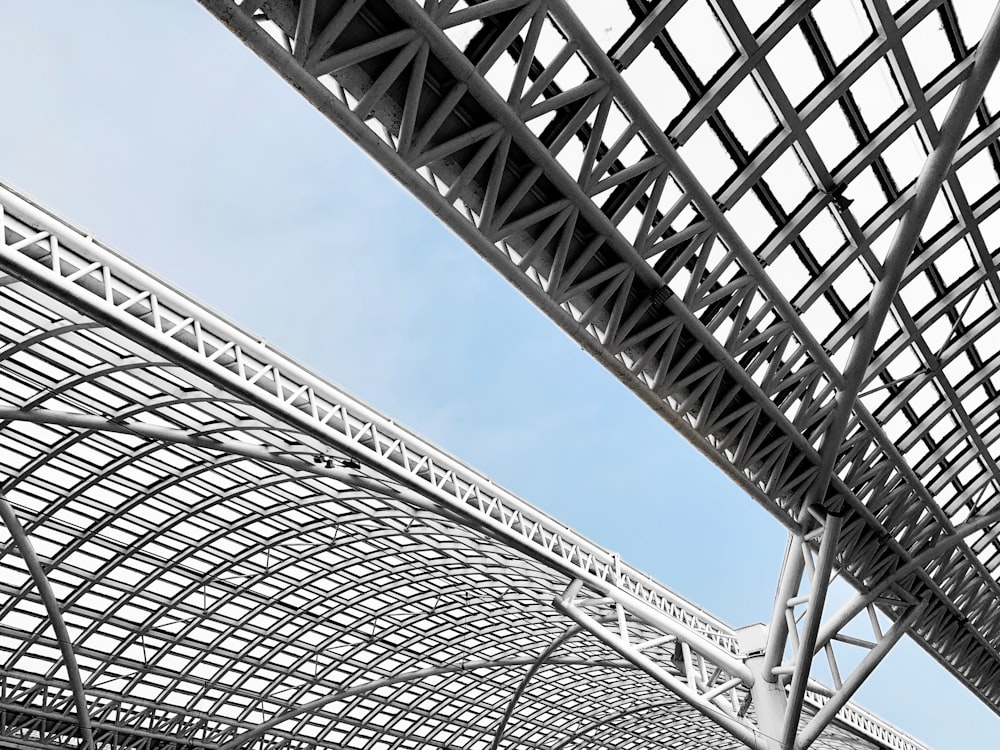 low angle photography of gray metal tower under blue sky during daytime