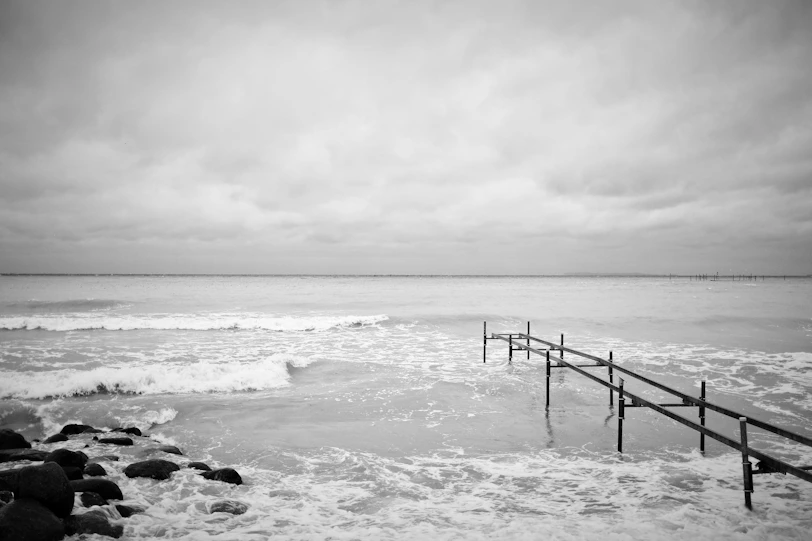 grayscale photo of sea waves crashing on rocks