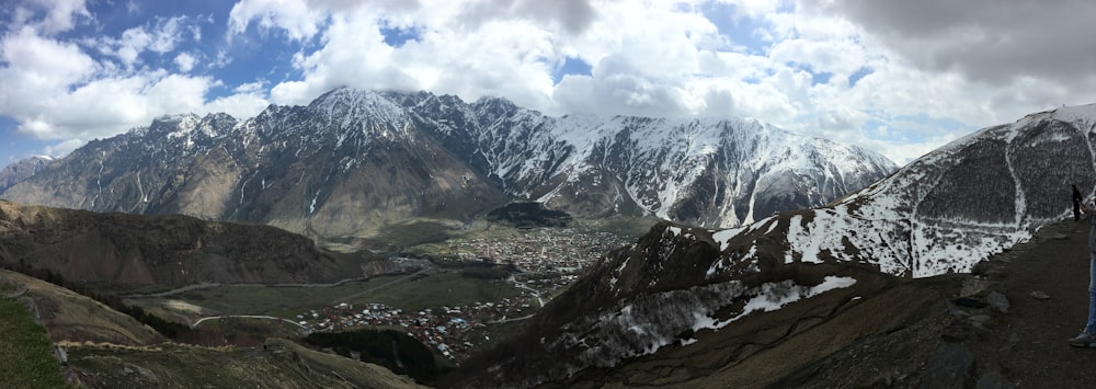 green and white mountains under white clouds and blue sky during daytime