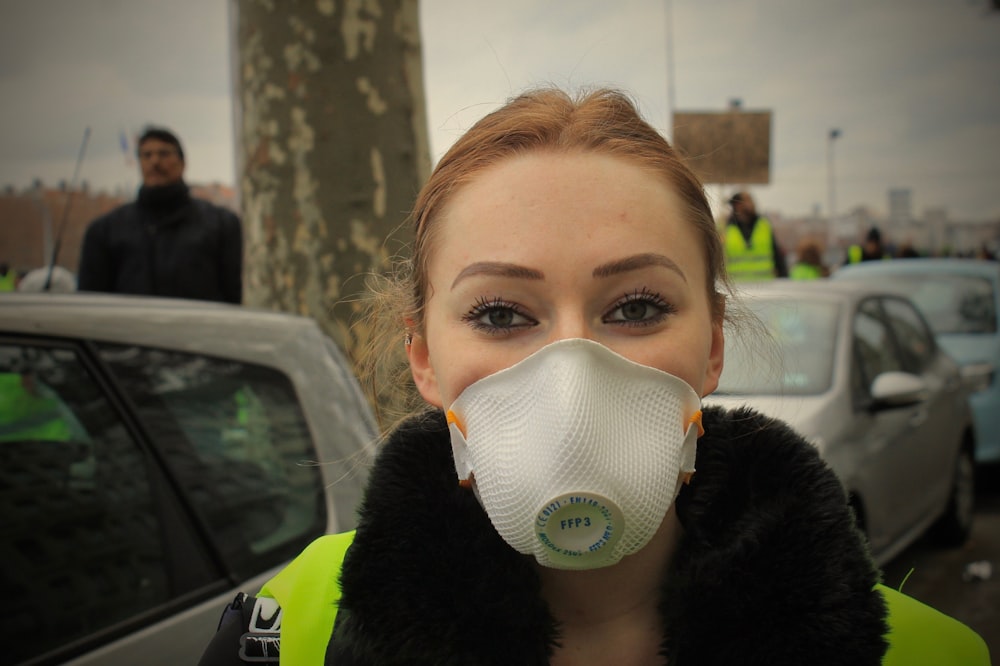 woman in black fur jacket wearing white face mask