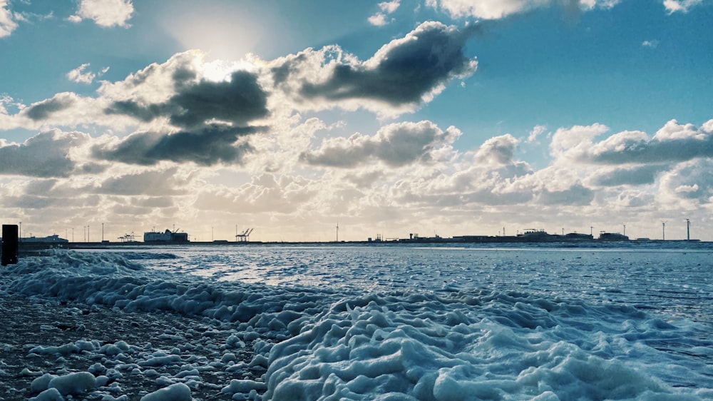 white ship on sea under white clouds and blue sky during daytime