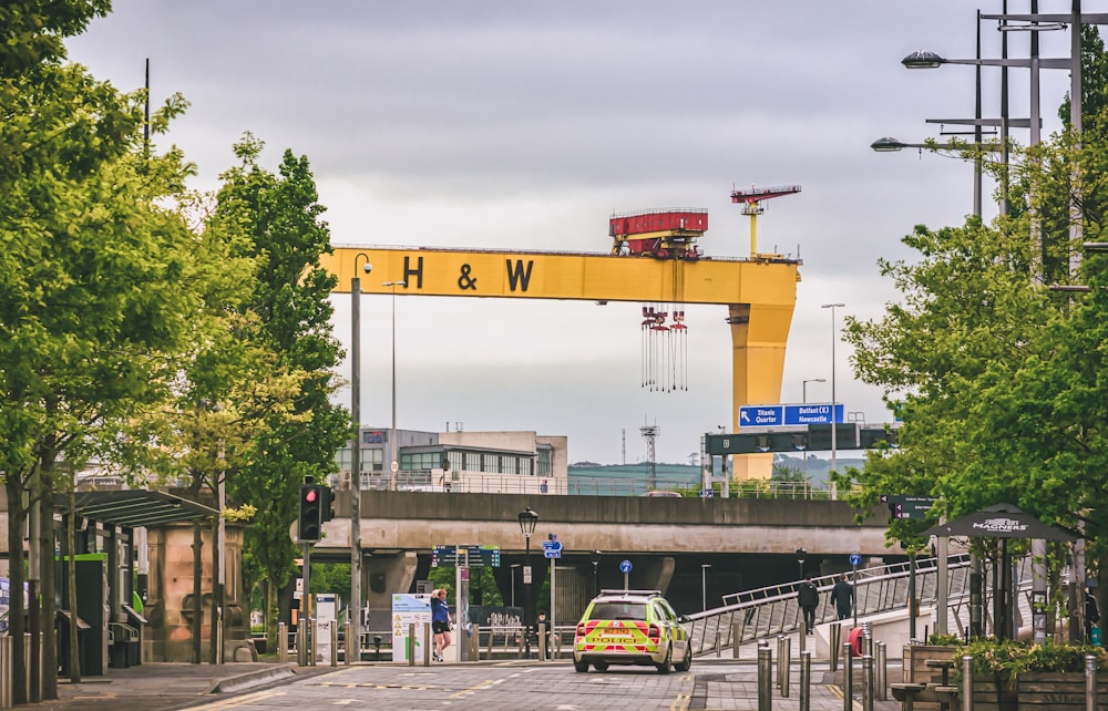 yellow and white crane near white and yellow bus during daytime