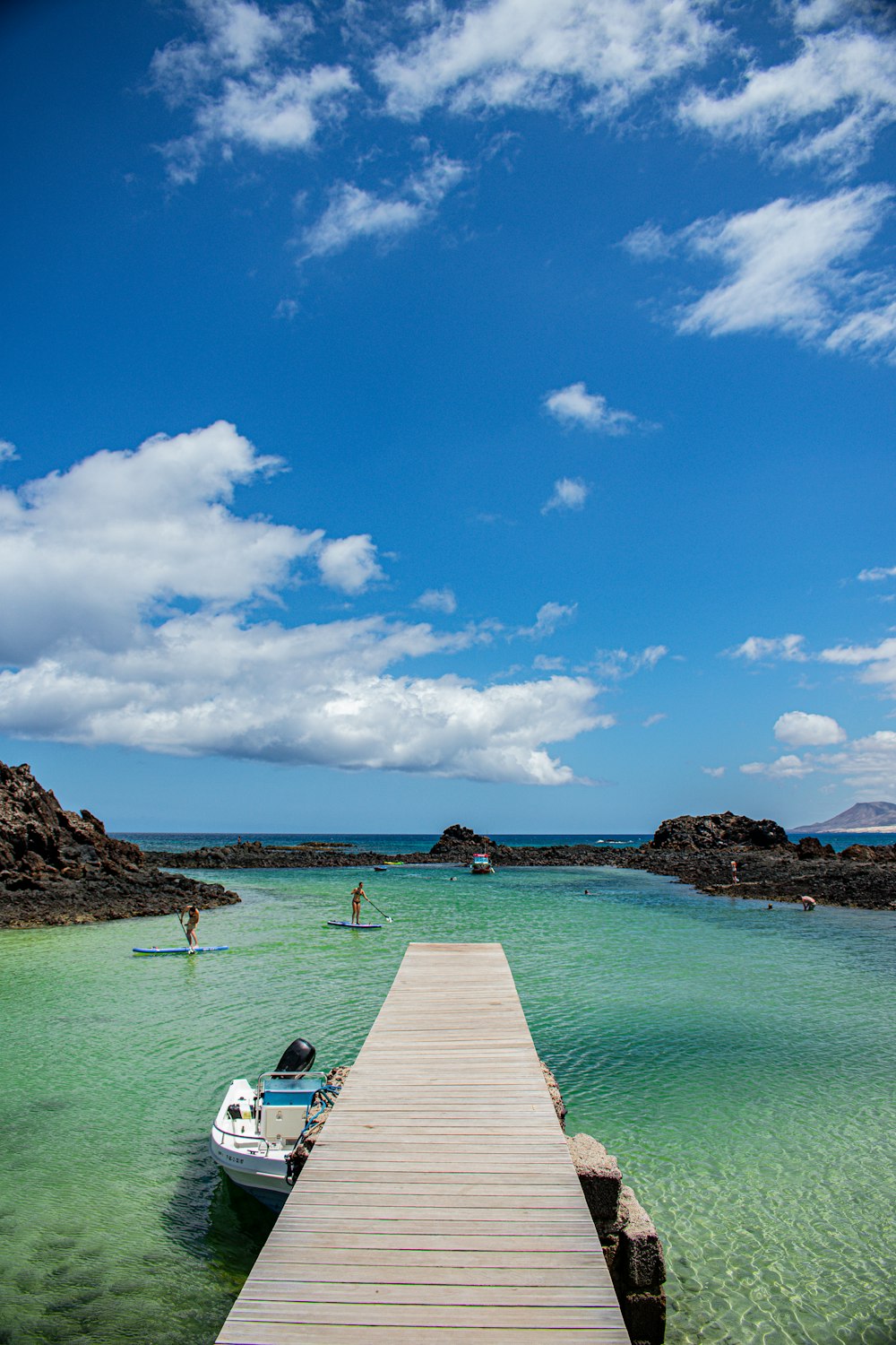 a small boat is docked at the end of a pier