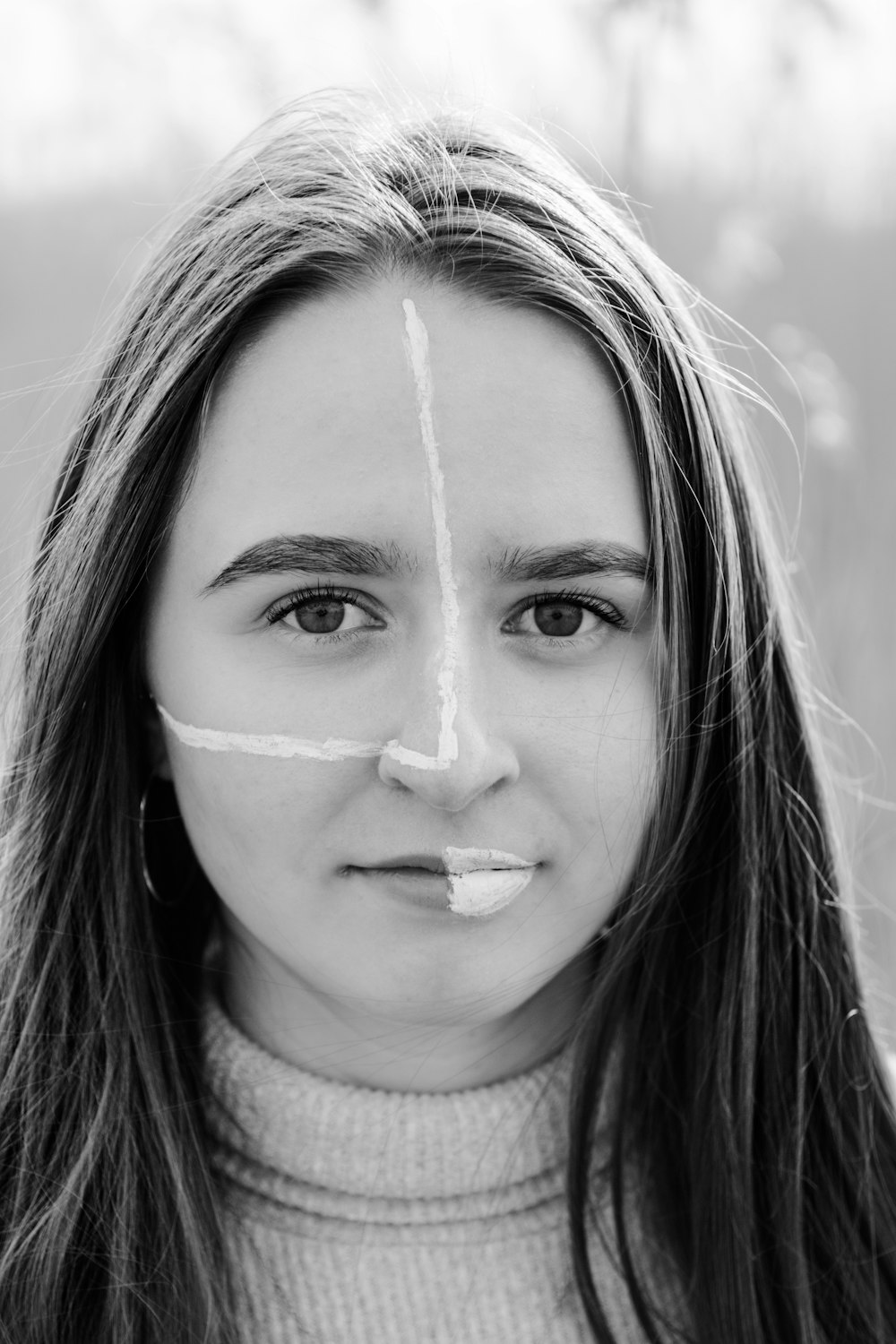 grayscale photo of woman with white powder on her face