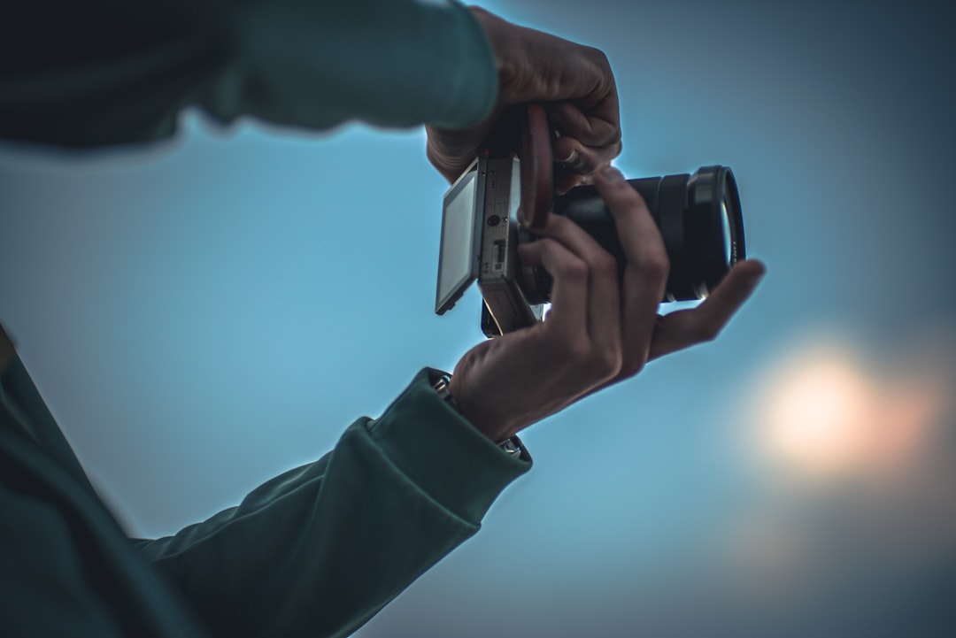 person holding black and silver camera