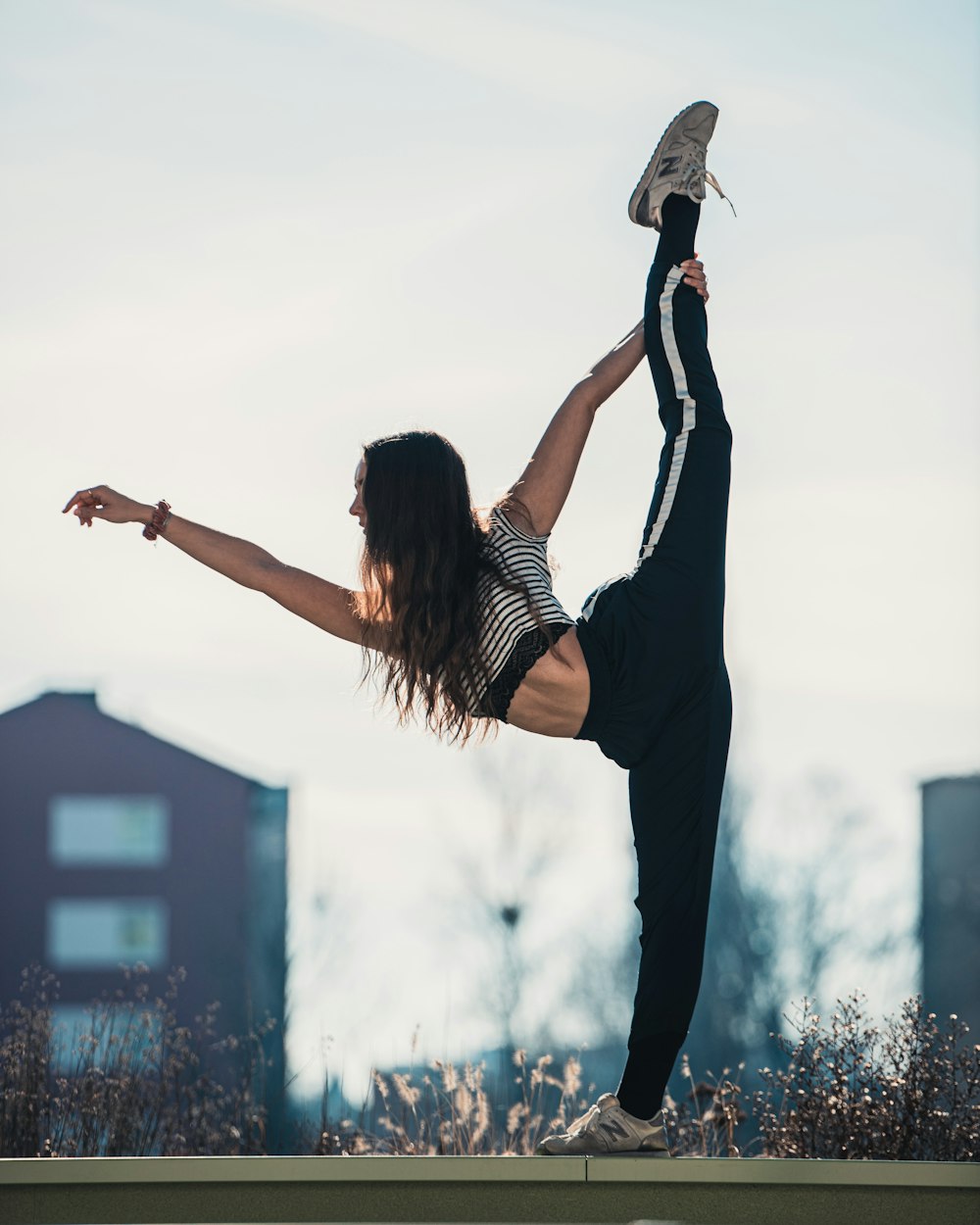 woman in black tank top and black pants doing yoga during daytime