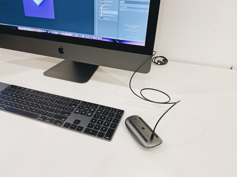 silver imac beside apple magic keyboard and apple magic mouse