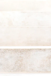 A close-up of textured stone steps leading to a hidden Cycladic cave house