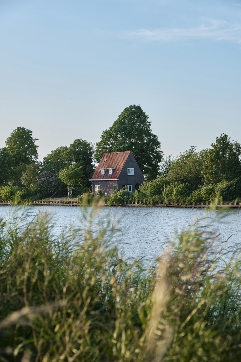 a house sitting on top of a lake surrounded by trees