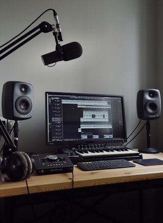 black flat screen computer monitor and black computer keyboard on brown wooden desk