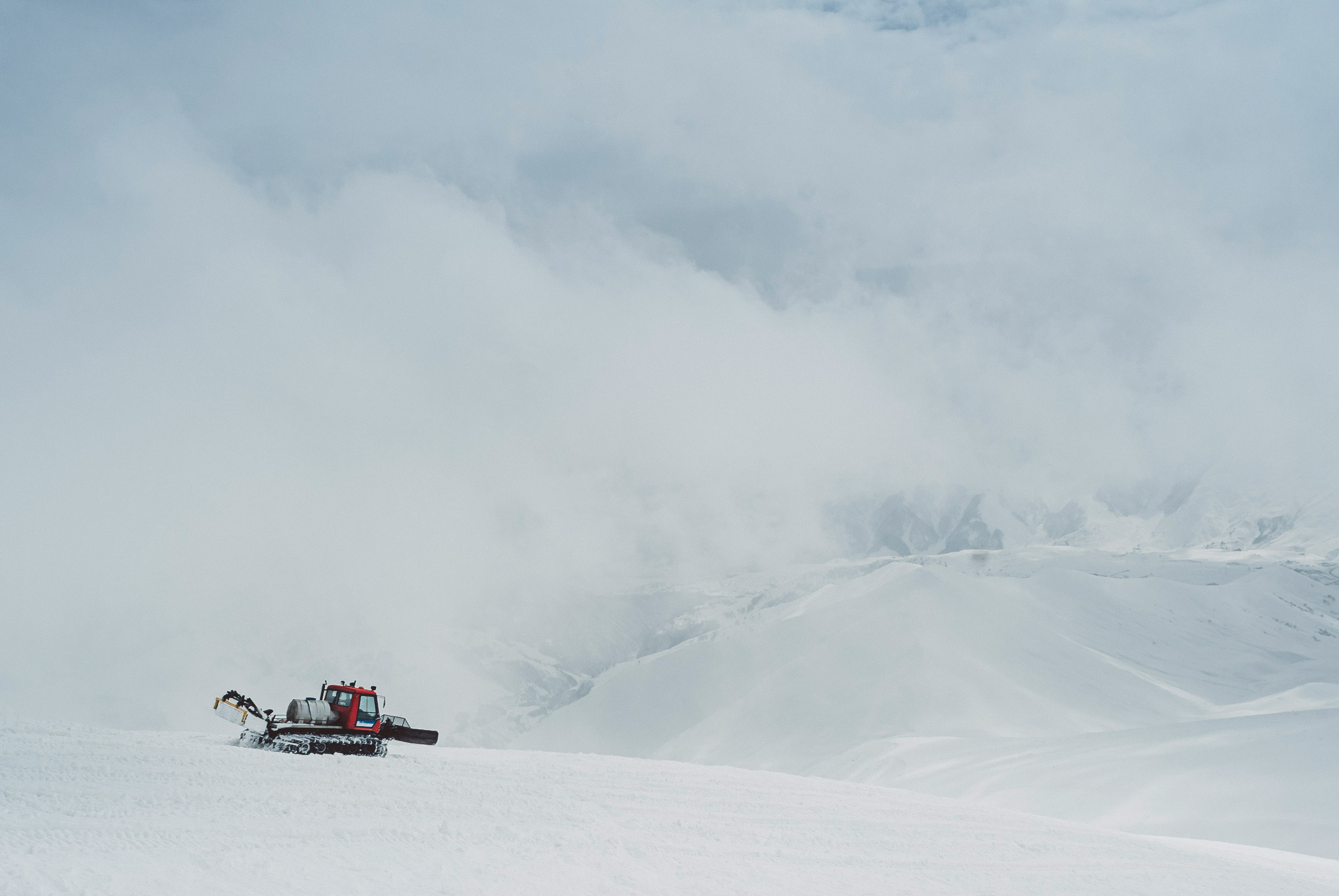 red car on snow covered mountain during daytime