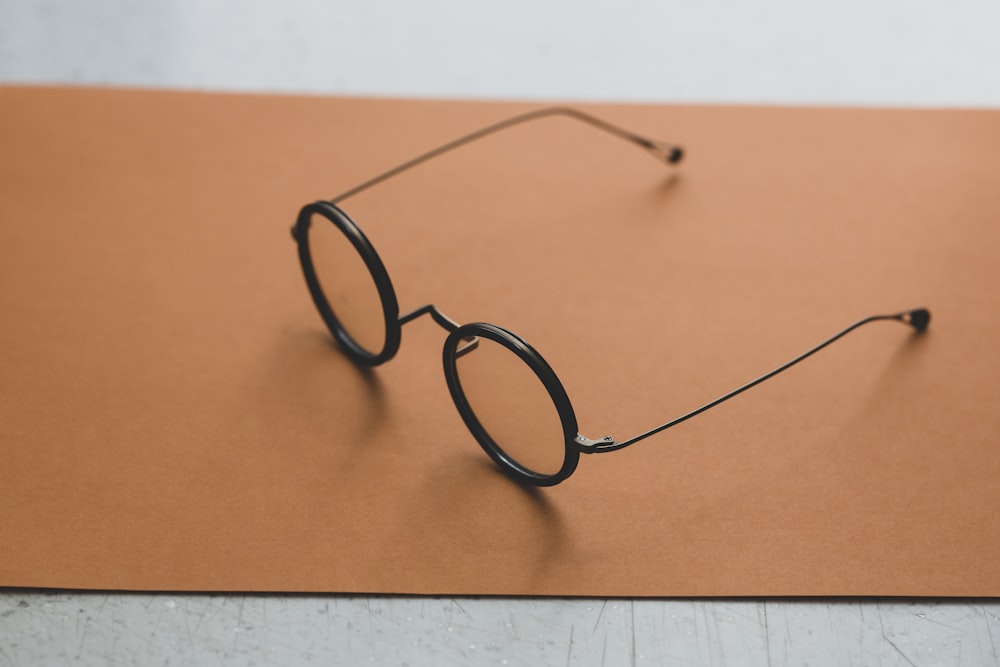 occhiali da vista con montatura nera su superficie arancione