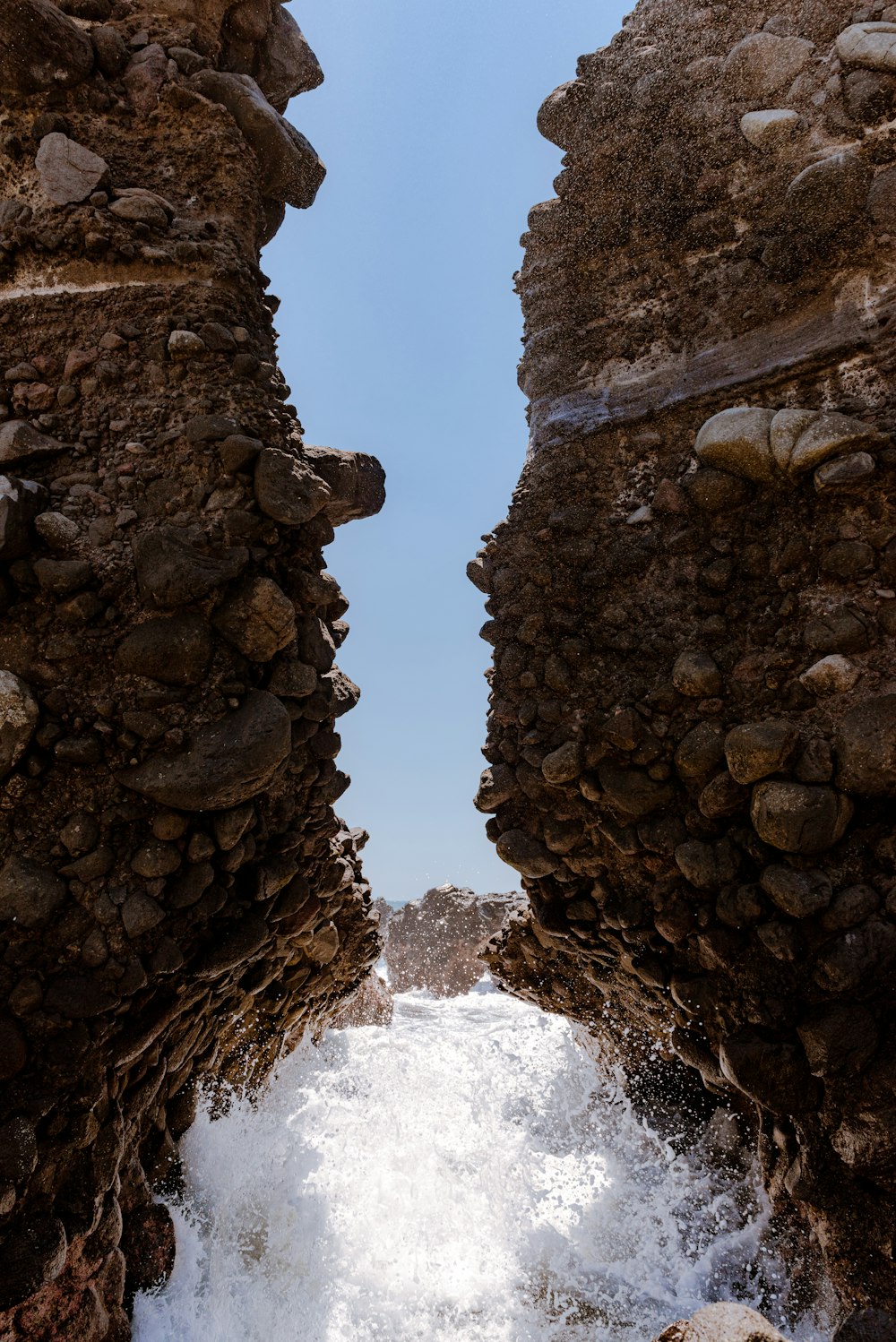 brown rock formation near water falls during daytime