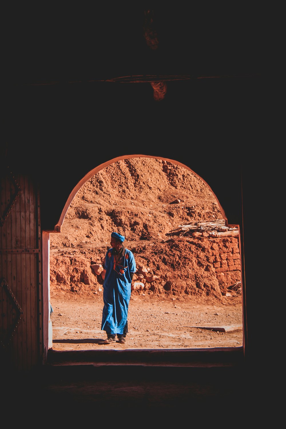 woman in blue hijab standing on brown sand during daytime